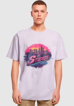 Tricou din bumbac lavandă deschisă, având un grafic vibrant al unui orizont cu accente roz și albastre, și textul "2Y STUDIOS" scris cu litere îndrăznețe.