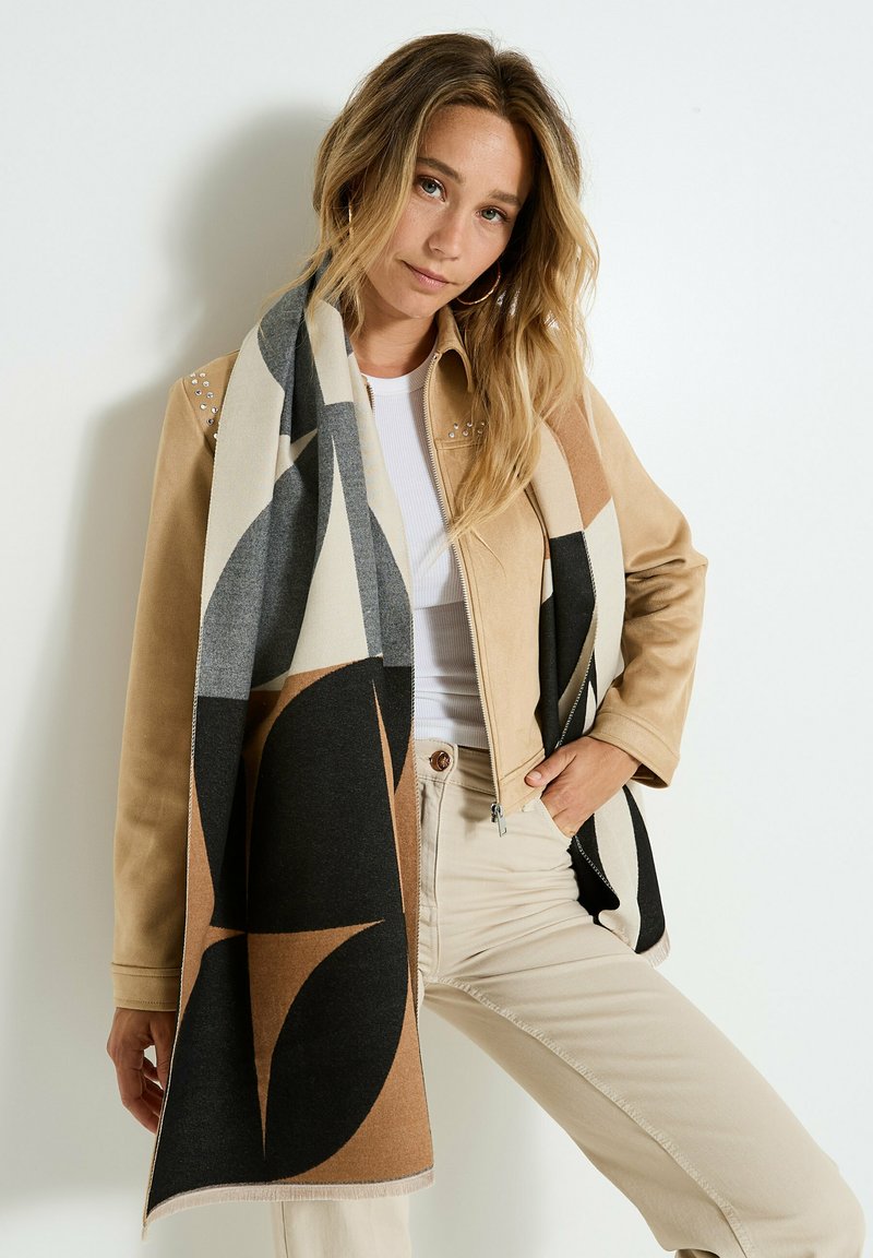 Bufanda con patrones geométricos en tonos neutros de negro, beige y gris. Fabricada con un textil suave y una textura lisa.