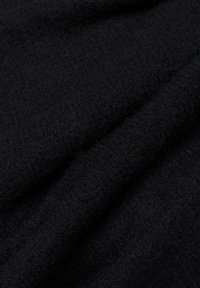 Schwarzer, strukturierter Stoff mit einer weichen, flauschigen Oberfläche, der lockere, gestrickte Fasern aufweist, die ein gemütliches Aussehen erzeugen.