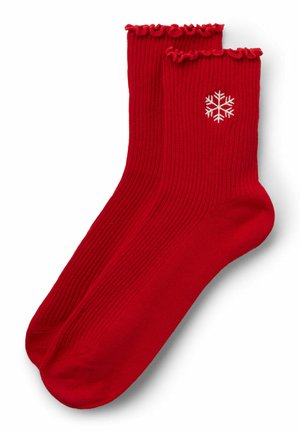 Calze rosse a coste con un bordo volant, caratterizzate da un motivo di fiocchi di neve ricamato di colore bianco sul lato. Tessuto morbido.