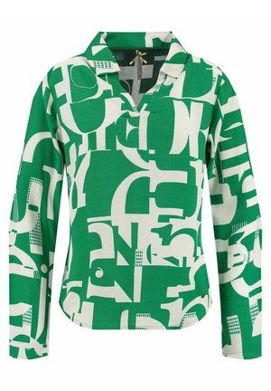Blouse verte à manches longues avec des formes géométriques abstraites blanches et un col avec une petite ouverture au niveau de l'encolure.