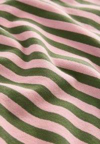 Tessuto morbido con strisce orizzontali rosa e verdi, leggermente stropicciato che mostra la texture e il motivo a maglia.