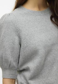 Szary sweter robiony na drutach z okrągłym dekoltem, bufiastymi krótkimi rękawami i prążkowanymi mankietami, o miękkiej strukturze i luźnym kroju.