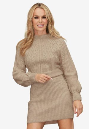Robe pull en beige clair avec texture côtelée. Présente un col rond haut et de longues manches bouffantes. Matériau doux et chaud.