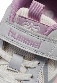 Grijze en lavendelkleurige kindersneaker met bovenwerk van mesh, klittenbandsluiting en veters. "Hummel" logo gedrukt op de band, zichtbare gestructureerde accenten.