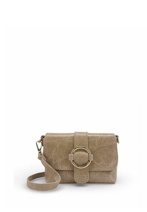 Petit sac bandoulière en cuir beige avec une grande boucle circulaire dorée et une sangle de poignet détachable sur fond blanc.