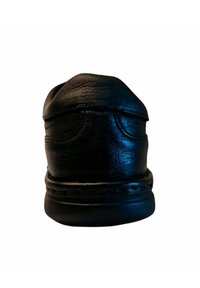 Zapato de cuero negro con punta redondeada, textura suave, detalles cosidos y un interior blando. La suela está acolchada para mayor comodidad.