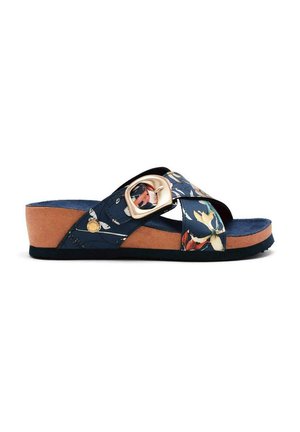 Sandalia deslizante azul marino con patrón floral y suela intermedia de corcho marrón. Cuenta con una tira ancha con una hebilla decorativa dorada y una suela texturizada para mayor agarre.