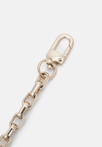 Catena in metallo dorato con grandi anelli e un gancio a scorrimento. La superficie è lucida e liscia, con un anello di attacco circolare.