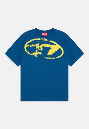 T-shirt Diesel bleu à manches courtes avec un grand graphique ovale jaune usé et une étiquette rouge Diesel à l'intérieur du col.