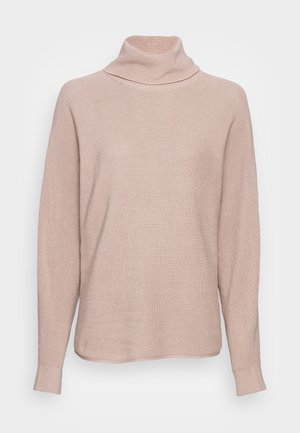 Pull à col roulé rose clair avec une texture côtelée, à manches longues et à coupe décontractée. Le tissu semble doux et léger.