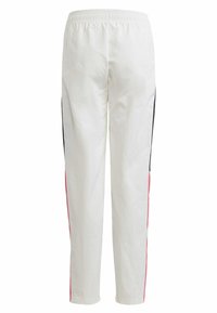 Witte joggerbroek met een elastische tailleband, zwarte zijstrepen en roze accenten, met een gladde textuur en een taps toelopende pasvorm.