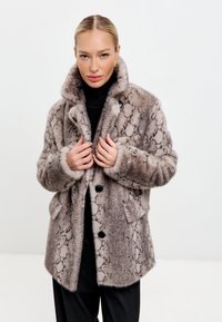 Barna és szürke műszőrme kabát, kígyóbőr mintával, gombos záródással és két elülső zsebbel. Magas gallérral és puha tapintású anyaggal rendelkezik.