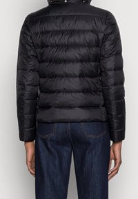 Czarna kurtka puchowa o pikowanej fakturze, z kapturem, długimi rękawami i gładkim, błyszczącym wykończeniem. Widok z tyłu pokazuje poziome przeszycia.