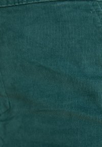 Τερακούτα υφασμάτινη καμπαρντίνα με κατακόρυφες ραβδώσεις, που εμφανίζει μια απαλή υφή. Επικεντρωθείτε στο συνεπές μοτίβο και την πλούσια κορεσμό χρώματος.