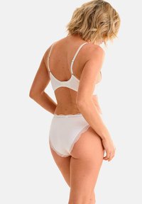 Witte lingerie set met kantafwerking en verstelbare bandjes. De beha heeft een gladde stof en de slipjes hebben een klassieke snit met gekartelde randen.