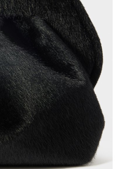 Borsa nera realizzata in materiale morbido simile alla pelliccia, con una forma arrotondata. Presenta un design leggermente stropicciato e una texture liscia.