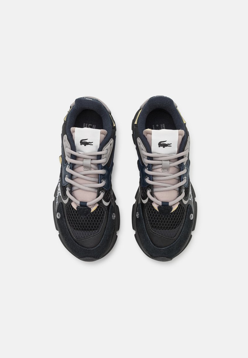 Baskets noires et grises en mesh et daim, avec une semelle épaisse, des lacets contrastés et un logo discret sur la languette.