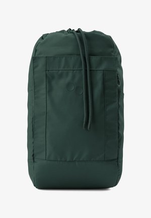 Sac à dos en nylon vert avec une fermeture à cordon, poche avant et deux accents circulaires. Texture lisse avec une forme structurée.