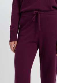 Paarse gebreide broek met een zachte textuur, voorzien van een trekkoord in de taille en geribbelde boorden, met een gezellige, aansluitende pasvorm.