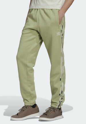 Pantalones de chándal verde claro, hechos de una tela suave, con cinturilla elástica, bolsillos laterales y una franja estampada a lo largo de la pierna exterior.