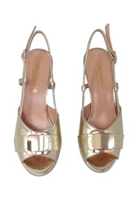 Scarpe slingback metalliche dorate con punte aperte, dotate di una larga fascia e una fibbia quadrata decorativa. Texture liscia con una finitura lucida.