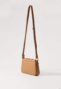 Borsa a tracolla in pelle color tan con forma strutturata, tracolla regolabile, chiusura con zip e dettagli in hardware dorato. Texture liscia, design moderno.