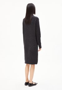 Robe en maille grise à manches longues et coupe ample, arrivant au milieu du mollet. Présente une texture côtelée et un design uni, avec des détails minimaux.