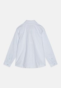 Camicia a maniche lunghe, a righe azzurro chiaro con colletto aperto, polsini abbottonati e dettagli sul retro. Tessuto morbido con accenti pastello.