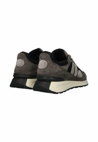 Grå mockaskor med svarta nätinslag, utrustade med en vit mellansula och texturerad gummisula, designade för komfort och stabilitet.