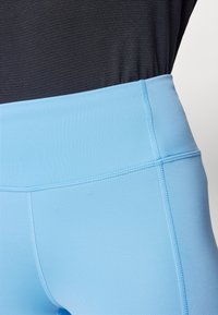 Leggings de tiro alto azul claro con una textura suave, que presentan una cinturilla ancha y costuras planas para mayor comodidad.