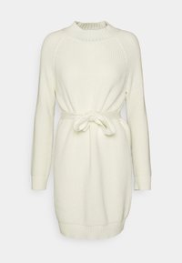 Neulemekko off-white värissä, jossa on pitkät hihat, ribbaus kaula-aukossa ja hihoissa, vyöllä varustettu vyötärö ja rento istuvuus. Sisältää tekstuurin.