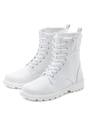 Bottes de cheville blanches en toile avec un bout arrondi, semelle en caoutchouc plate, fermeture à lacets à l'avant et fermeture éclair sur le côté. Texture lisse.
