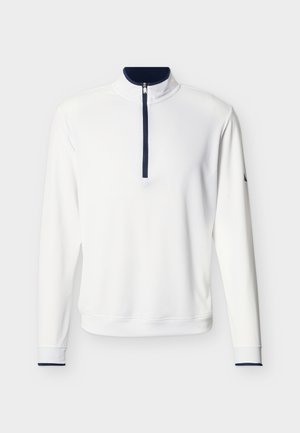 Valge pika varrukaga pullover tumesinise kvartstõmbluku, krae voodri ja varrukaääristega, esitatud ühevärvilisel heledal taustal.