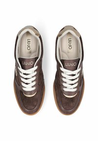 Baskets en daim marron avec lacets blancs, accents dorés et semelle en caoutchouc. Présentent le logo de la marque sur la languette et le côté. Intérieur rembourré pour le confort.