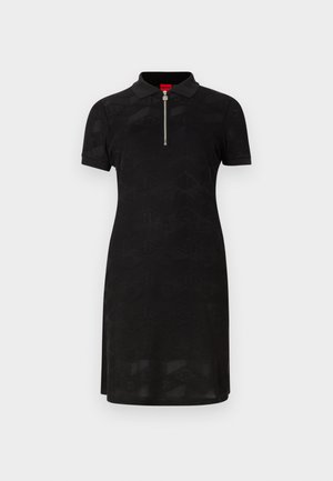 Črna polo obleka ima kratke rokave, zadrgo pri ovratniku in teksturiran geometrijski vzorec po celotni površini, izdelana je iz gladkega blaga.