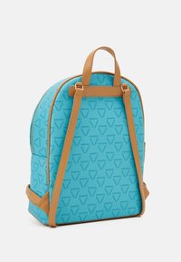 Blå ryggsäck med en strukturerad yta som har ett upprepat logomönster, bruna läderremmar och detaljer, samt dragkedjest ängning.