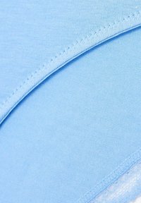 Tessuto azzurro chiaro con una texture liscia, dotato di una cucitura piatta lungo il bordo. Il materiale è morbido ed elasticizzato, ideale per il comfort.