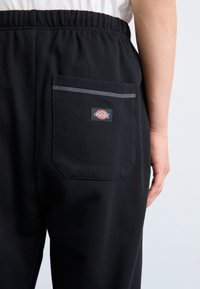 Sorte sweatpants lavet af bomuld. Har en elastisk talje og en baglomme med en kontrasterende grå kant og logo-patch.
