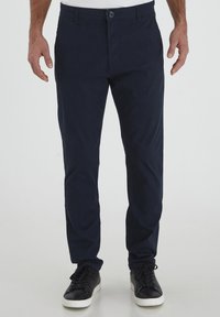Navy blue cotton chinos with a slim fit, flat front, and belt loops. Finished with a single button closure and side pockets.