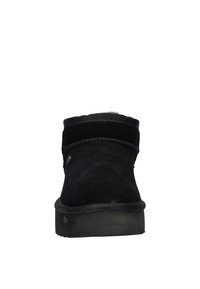 Zwarte suède enkelboot met een ronde neus, gestikte details en een rubberen zool met textuur. Eenvoudig ontwerp zonder opvallende patronen of accenten.