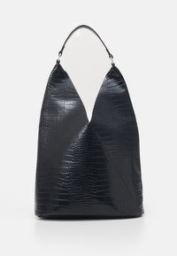 Svart väska i konstläder med krokodilstruktur, har en asymmetrisk design, en stabil bas och en slät, glansig yta. Utrustad med ett böjt handtag.