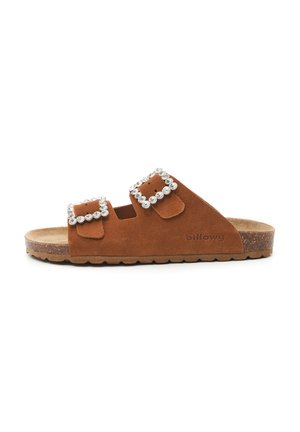 Sandales en suede marron avec deux larges bandes ornées de strass carrés, une semelle en liège et une semelle intérieure texturée.