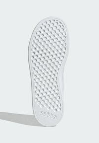 Suela de zapato de goma blanca con un patrón de panal y un logotipo de marca en relieve, con un acabado suave y texturizado en los bordes.