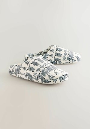 Bavlnené papuče na nazúvanie s bielym pozadím a modrým vzorom zvierat a rastlín. Okrúhly špičky a jemná textúra, ideálne na nosenie v interiéri.