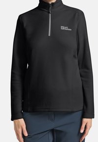 Czarna bluza polarowa z półzamek i teksturowaną powierzchnią, z małym, szarym logo na górnej lewej stronie.