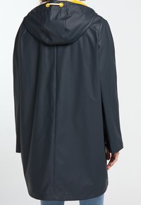 Impermeabile, giacca da pioggia blu navy con cappuccio, hardware color oro e vestibilità ampia. Materiale testurizzato con una finitura liscia, progettata per il comfort.