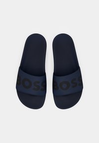 Navy blue slide sandals with textured footbeds and wide straps displaying the word "BOSS" in large black letters.