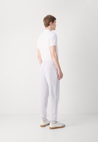 HUGO DAYOTE - Jogginghose - light pastel purple