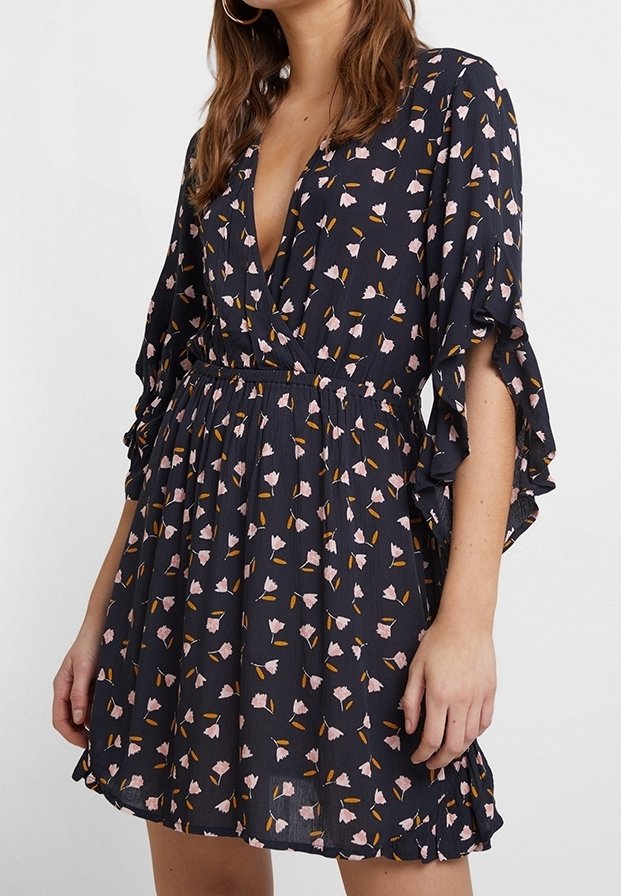 Marinblå klänning med korta volangärmar, djup V-ringning och elastisk midja. Drags till med rosa blommönster och en utsvängd kjol. Lättviktigt material.